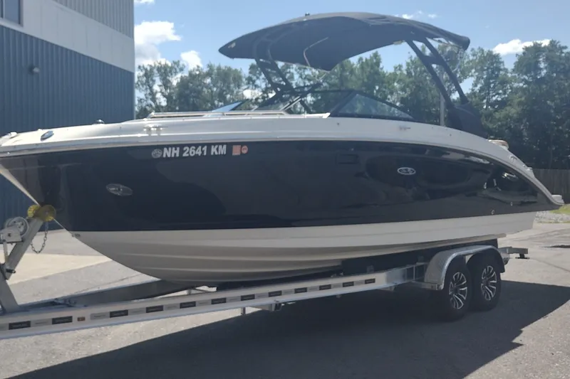 Slide: The Image of 2023 Sea Ray SDX 270 boat on trailer, parked outdoors under a clear sky. - 2