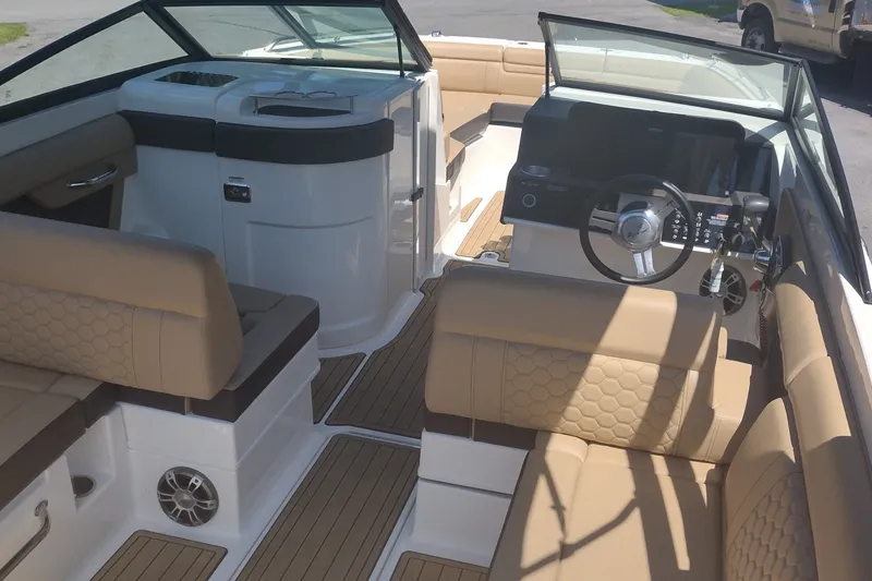 Slide: The Image of Luxurious interior of 2023 Sea Ray SDX 270 boat with tan seating and modern dashboard. - 16