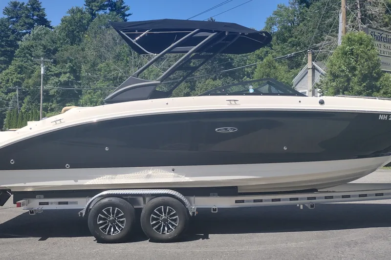 Slide: The Image of 2023 Sea Ray SDX 270 boat on trailer, parked outdoors with trees in background. - 4