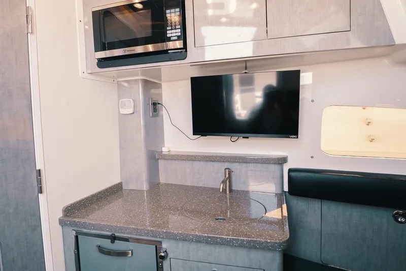 Slide: The Image of Modern kitchenette in 2018 HCB 53 Suenos boat with TV, microwave, and sink. - 26