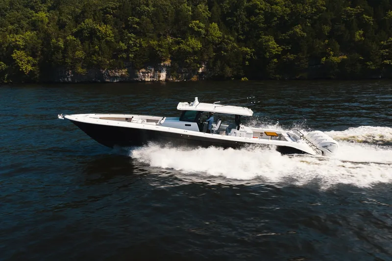 Slide: The Image of 2018 HCB 53 Suenos boat cruising on a scenic lake with lush forest backdrop. - 55