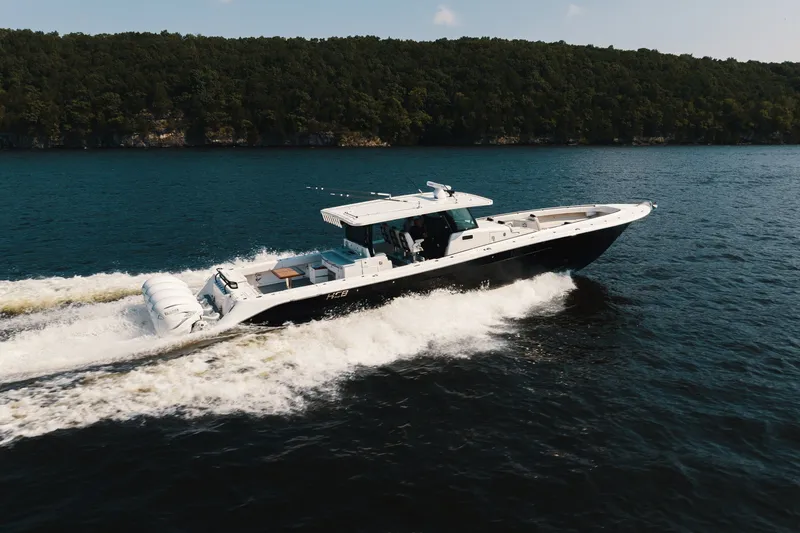 Slide: The Image of 2018 HCB 53 Suenos boat cruising on a lake with forested shoreline. - 59