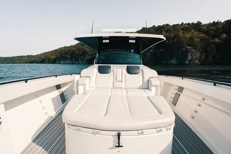 Slide: The Image of Luxurious 2018 HCB 53 Suenos boat interior with plush seating, cruising on a scenic lake. - 33