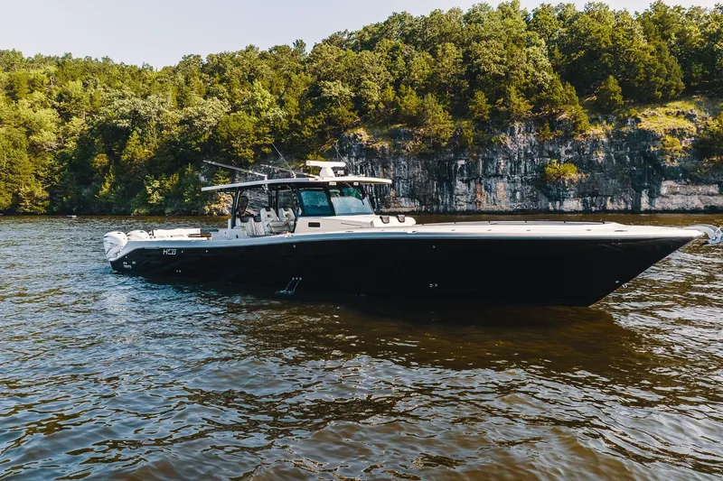The Image of 2018 HCB 53 Suenos boat cruising on a scenic lake with forested cliffs. - 1