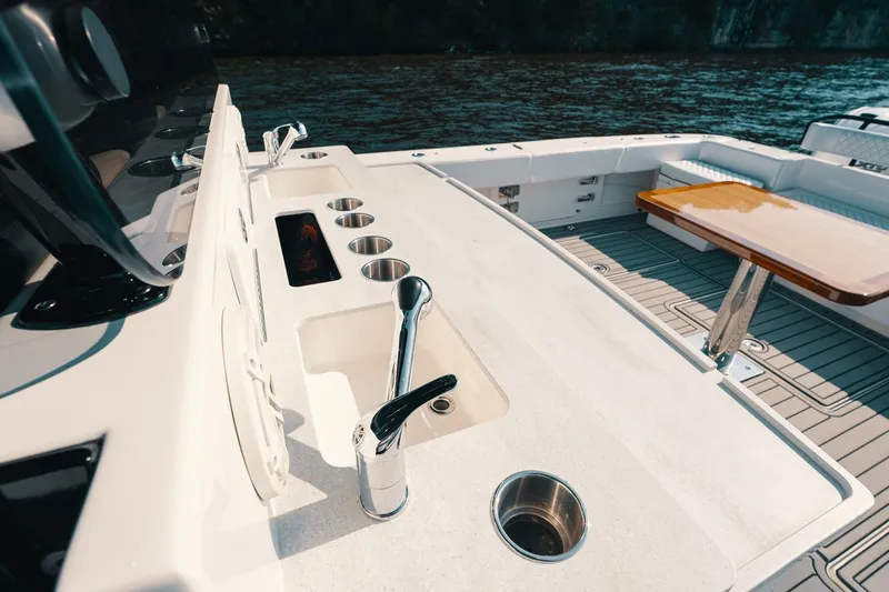 Slide: The Image of Luxurious 2018 HCB 53 Suenos yacht deck with sink, cup holders, and wooden table. - 32