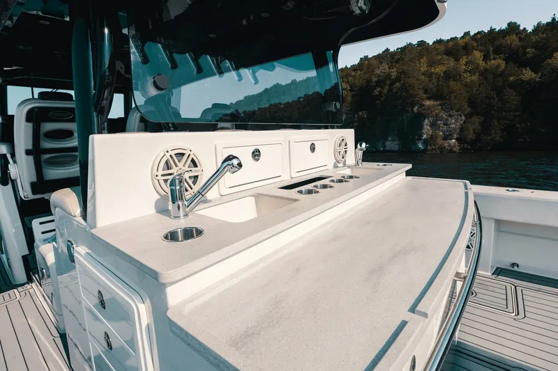 Slide: The Image of 2018 HCB 53 Suenos boat interior with sleek countertop and sink, set against a scenic backdrop. - 31