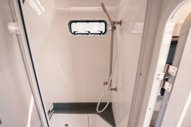 Slide: The Image of Shower area inside 2018 HCB 53 Suenos boat, featuring sleek design and window. - 29