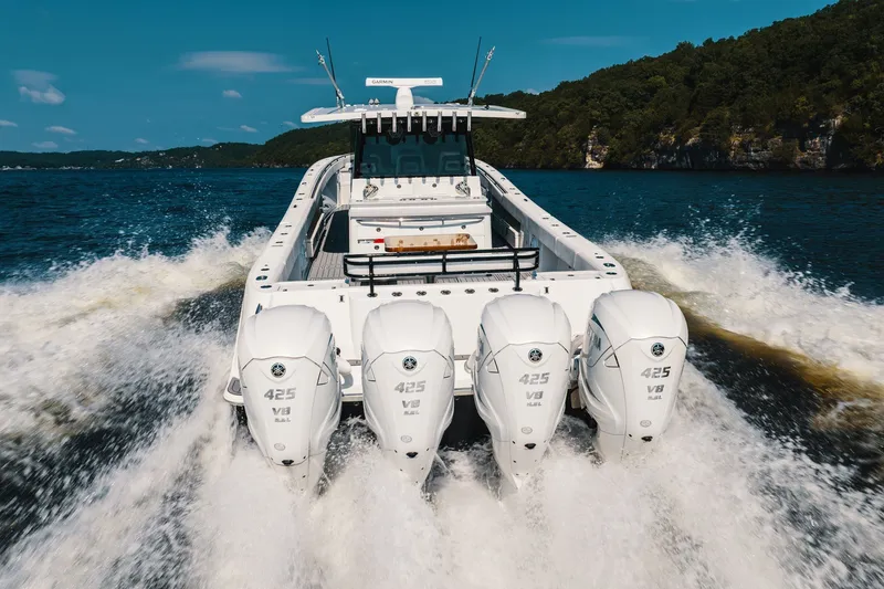Slide: The Image of 2018 HCB 53 Suenos boat with four powerful outboard engines cruising on a scenic lake. - 54