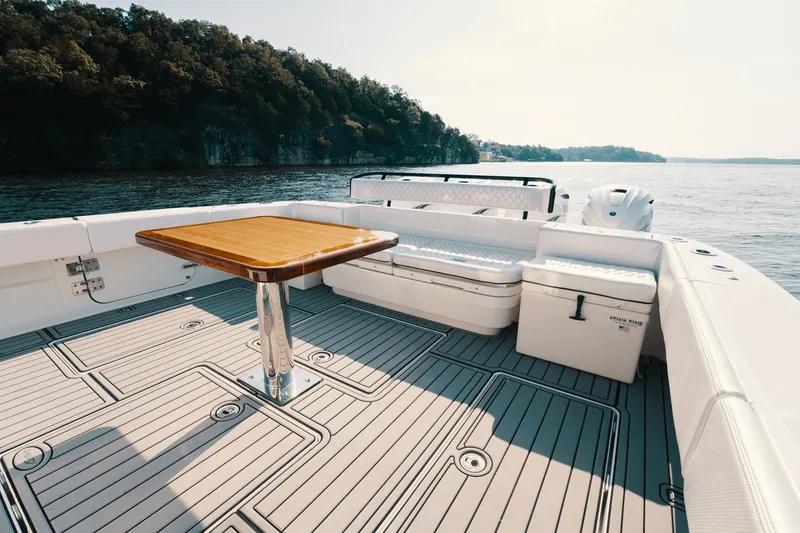 Slide: The Image of Luxurious 2018 HCB 53 Suenos yacht deck with seating and table, overlooking serene waters. - 16