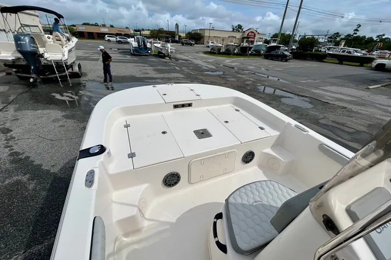 Slide: The Image of 2025 Carolina Skiff 19 LS boat interior, featuring seating and storage compartments in a parking lot. - 9