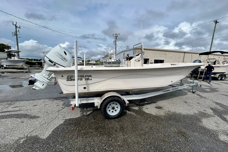 Slide: The Image of 2025 Carolina Skiff 19 LS boat on trailer, featuring Suzuki outboard motor. - 2