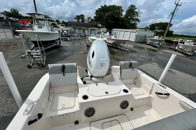 Slide: The Image of 2025 Carolina Skiff 19 LS boat with Suzuki outboard motor in a marina setting. - 8