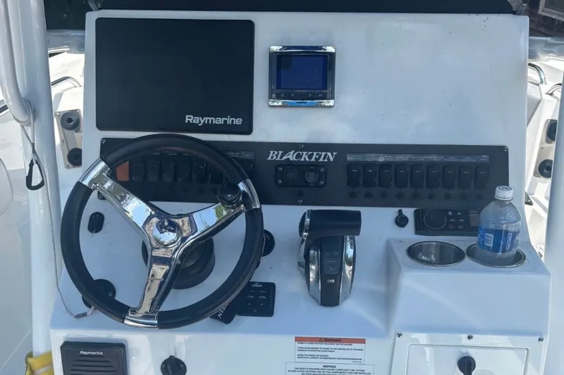 Slide: The Image of 2019 Blackfin 242 CC boat dashboard with steering wheel, Raymarine display, and control panel. - 3