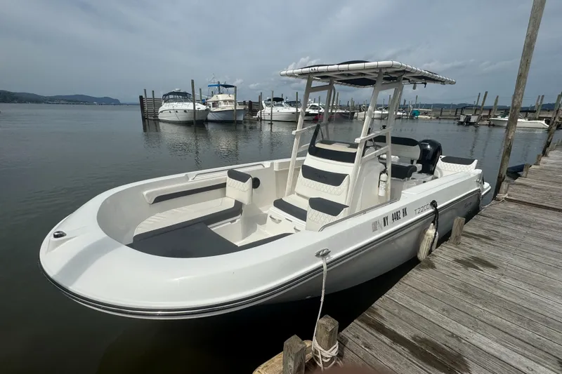 Slide: The Image of 2023 Trophy CC22 boat docked at a marina with other vessels in the background. - 2