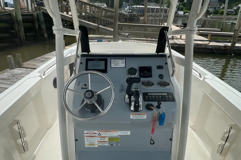 Slide: The Image of 2023 Trophy CC22 boat console with steering wheel and controls at dock. - 4
