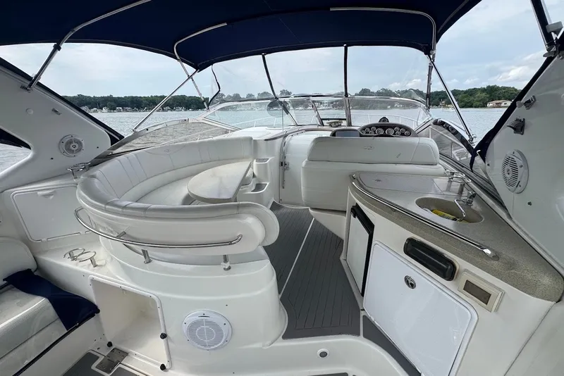 Slide: The Image of Luxurious 2004 Regal Commodore 3860 yacht interior with seating and kitchenette on a serene lake. - 8