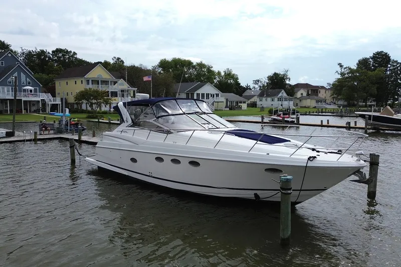 Slide: The Image of 2004 Regal Commodore 3860 yacht docked by waterfront homes, showcasing sleek design and luxury. - 4