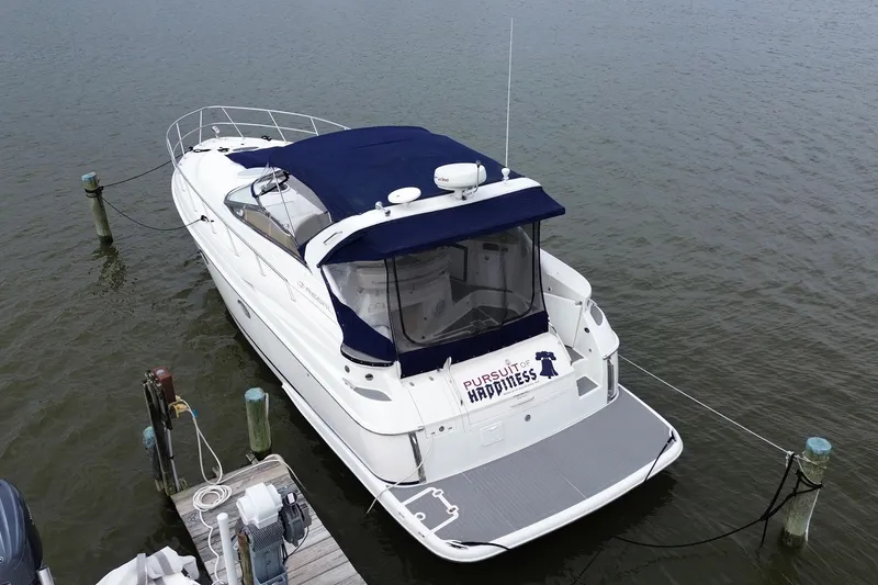 Slide: The Image of 2004 Regal Commodore 3860 yacht docked, featuring blue canopy and "Pursuit of Happiness" text. - 3