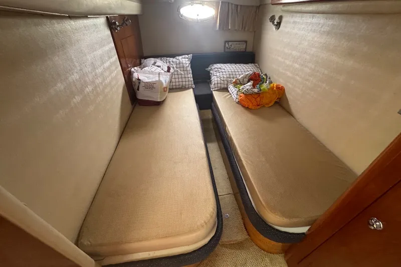 Slide: The Image of 2004 Regal Commodore 3860 cabin with twin beds, pillows, and a small window. - 19