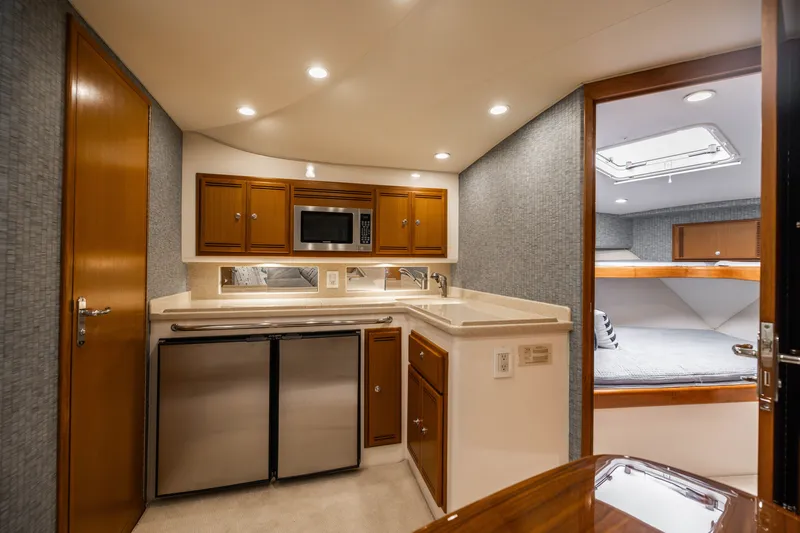 Slide: The Image of Luxurious 2007 Cabo 31 Express yacht interior with kitchenette and cozy sleeping area. - 31