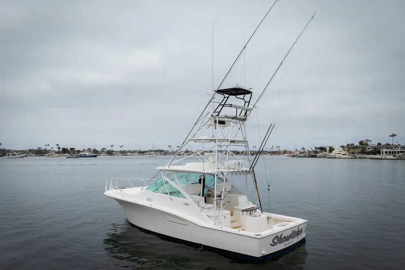 Slide: The Image of 2007 Cabo 31 Express boat on calm water, featuring fishing rods and a tower. - 47
