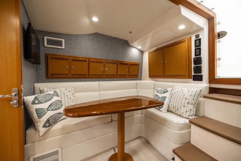 Slide: The Image of Luxurious 2007 Cabo 31 Express cabin interior with plush seating and elegant wooden table. - 2
