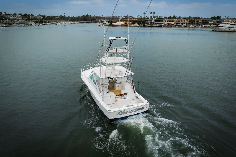 Slide: The Image of 2007 Cabo 31 Express boat cruising in a calm marina with waterfront homes. - 48