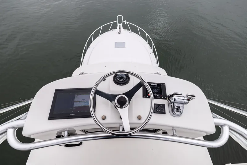 Slide: The Image of Helm of 2007 Cabo 31 Express boat with steering wheel and navigation controls. - 19