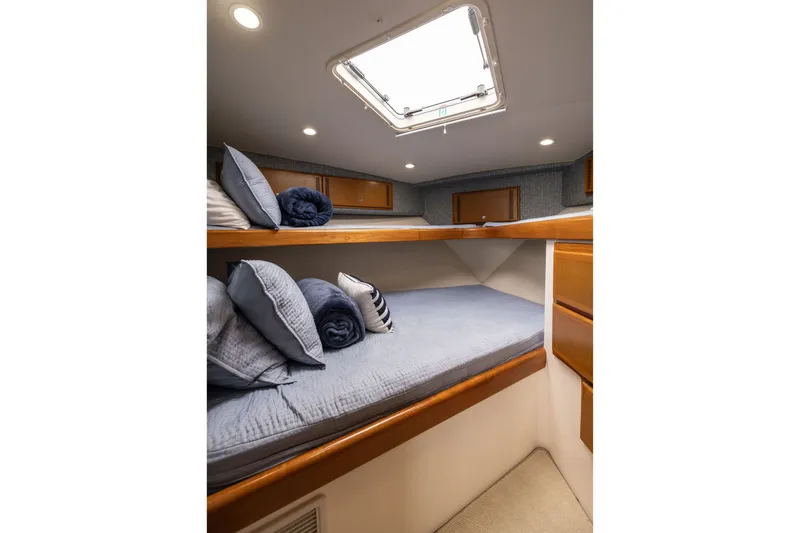 Slide: The Image of Interior cabin of 2007 Cabo 31 Express boat with cozy bedding and wooden storage. - 37
