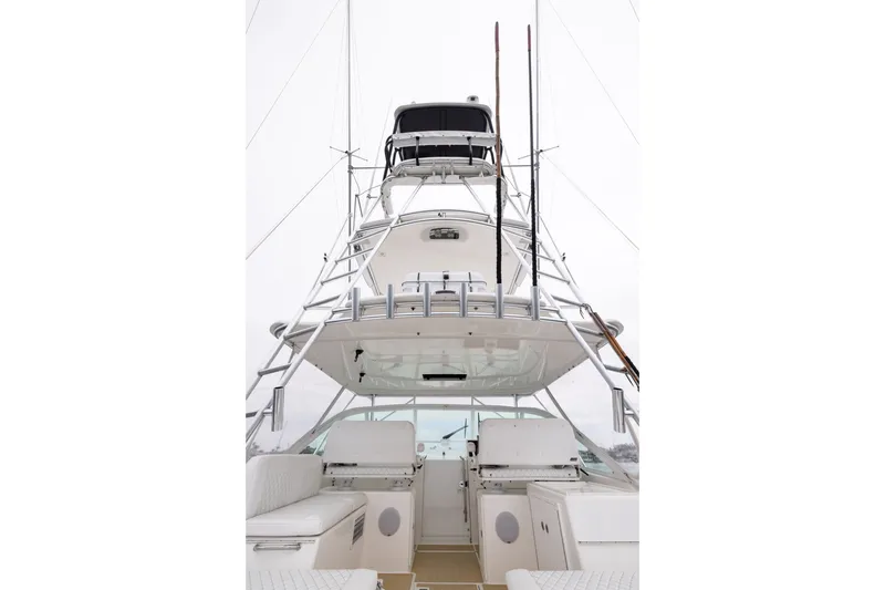 Slide: The Image of 2007 Cabo 31 Express boat with tower and fishing rods, viewed from the stern. - 17