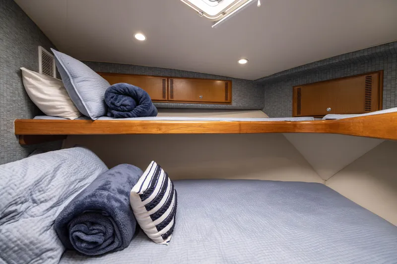 Slide: The Image of Cozy cabin interior of 2007 Cabo 31 Express with neatly arranged bedding and wooden accents. - 36