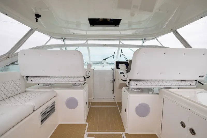 Slide: The Image of 2007 Cabo 31 Express boat interior with white seating and modern helm controls. - 6
