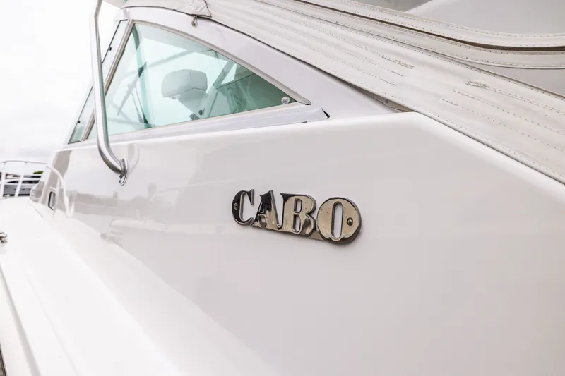Slide: The Image of 2007 Cabo 31 Express boat with logo and sleek white exterior. - 25