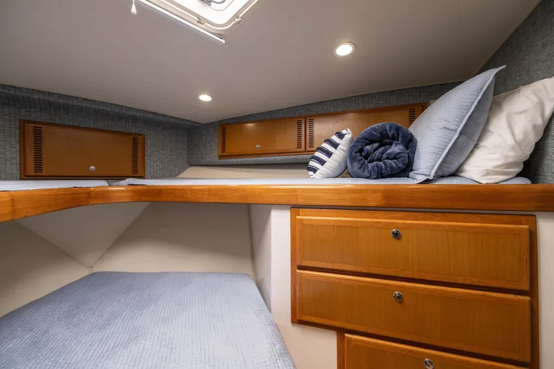 Slide: The Image of Cozy cabin interior of 2007 Cabo 31 Express boat with wooden storage and bedding. - 38