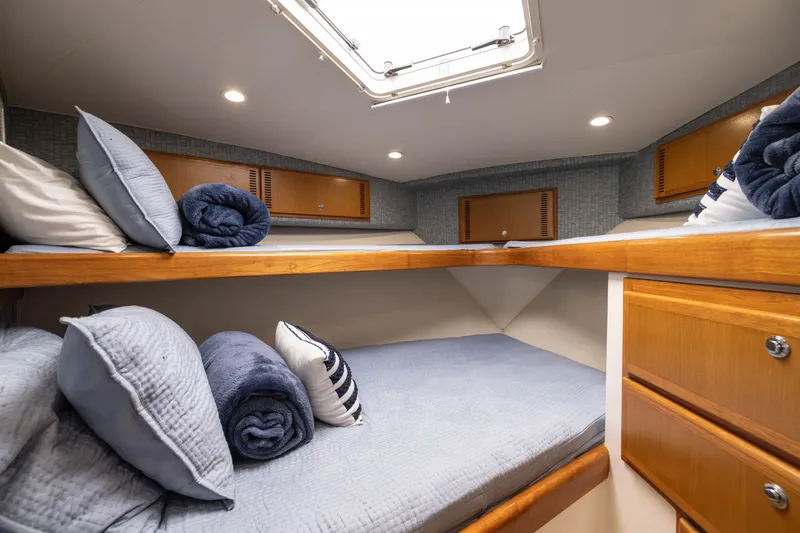 Slide: The Image of Interior cabin of 2007 Cabo 31 Express boat with cozy bedding and wooden storage. - 4