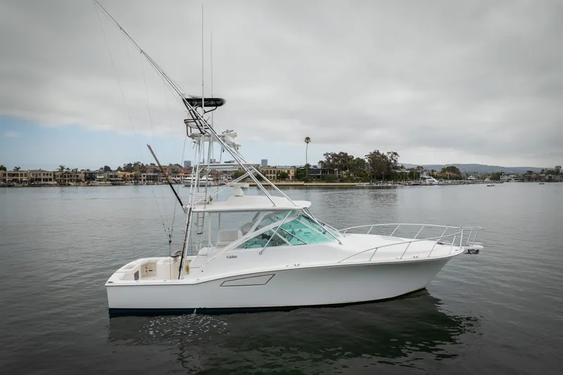 Slide: The Image of 2007 Cabo 31 Express boat on calm water with coastal background. - 54