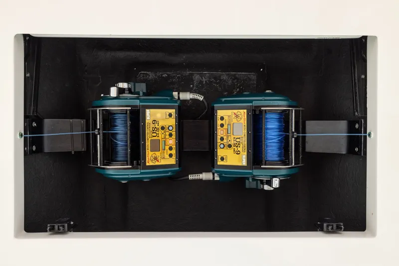 Slide: The Image of Dual electric fishing reels mounted on a black panel, featuring blue fishing line. - 10