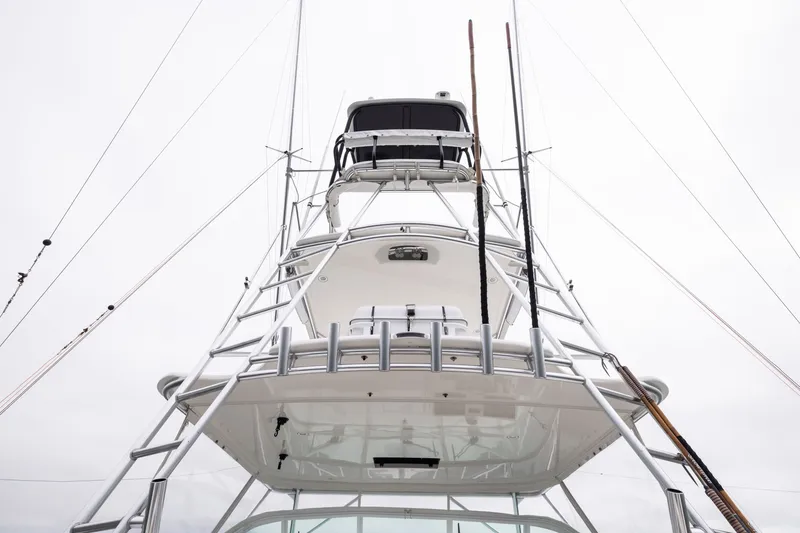 Slide: The Image of 2007 Cabo 31 Express boat tower with fishing rods and rigging against cloudy sky. - 16