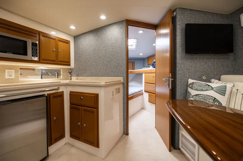 Slide: The Image of 2007 Cabo 31 Express interior with kitchenette, cozy cabin, and modern amenities. - 32