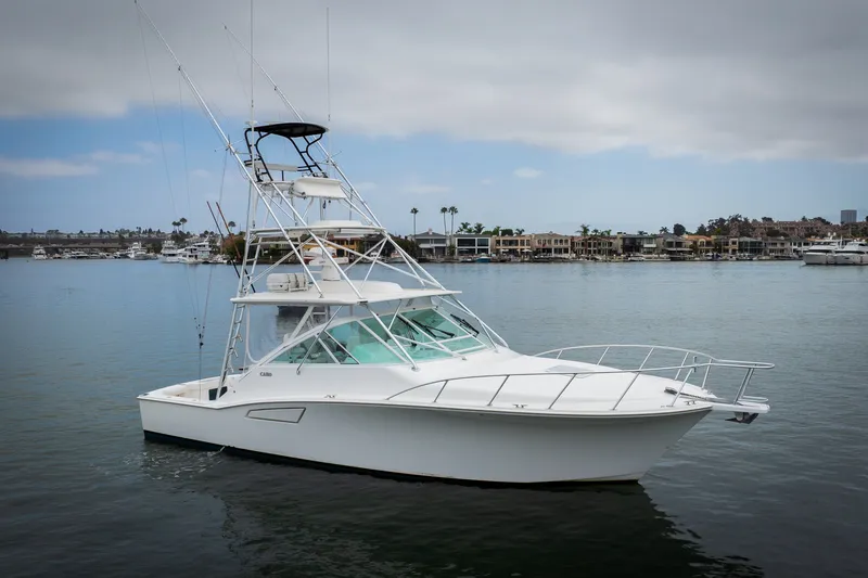 Slide: The Image of 2007 Cabo 31 Express boat on calm water with marina background. - 56