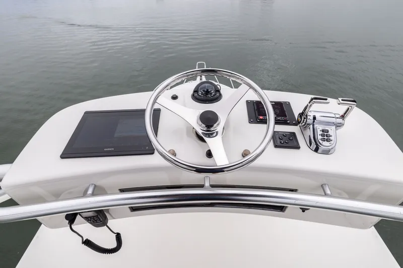 Slide: The Image of Helm of 2007 Cabo 31 Express boat with steering wheel and navigation controls. - 18