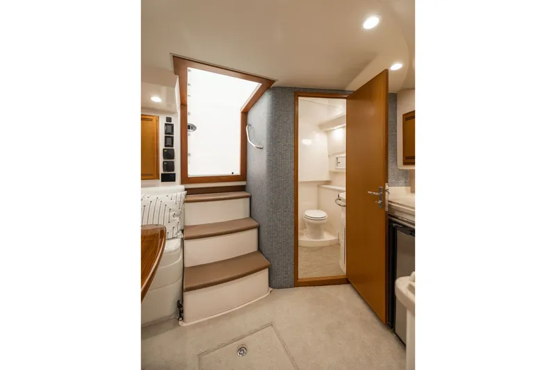 Slide: The Image of Interior of 2007 Cabo 31 Express yacht, featuring stairs and a compact bathroom. - 30