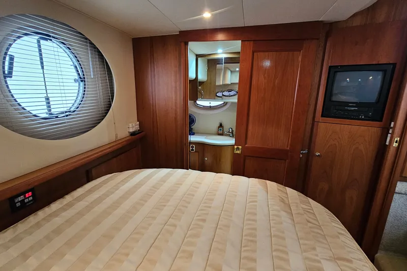 Slide: The Image of Luxurious 2003 Silverton 35 Motor Yacht cabin with wood accents and porthole window. - 29