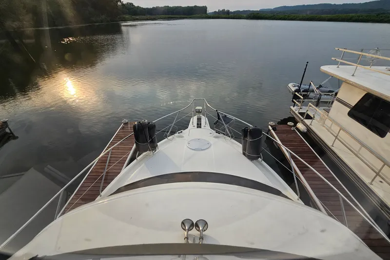 Slide: The Image of 2003 Silverton 35 Motor Yacht docked on a serene river at sunset. - 15