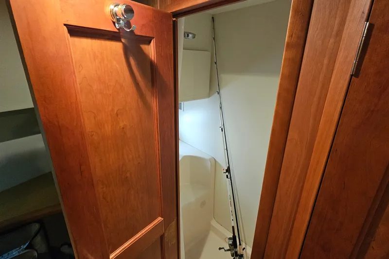 Slide: The Image of Interior of 2003 Silverton 35 Motor Yacht showing wooden door and compact shower area. - 26