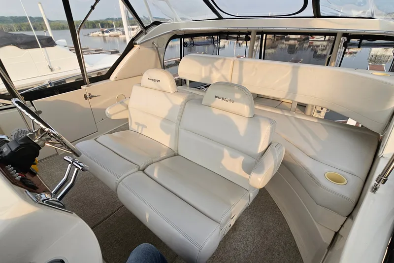 Slide: The Image of Interior of 2003 Silverton 35 Motor Yacht with white seating and helm, docked at marina. - 10