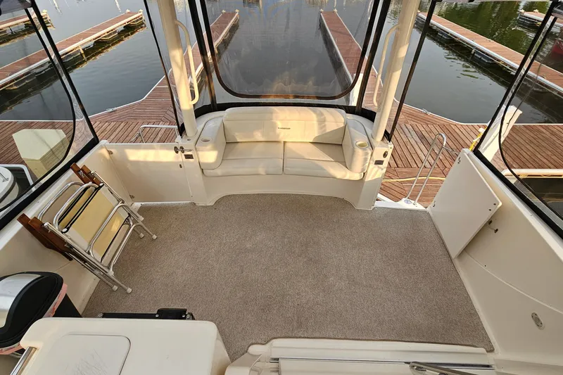 Slide: The Image of 2003 Silverton 35 Motor Yacht interior with seating, dock view, and carpeted floor. - 7