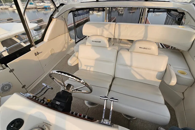 Slide: The Image of 2003 Silverton 35 Motor Yacht cockpit with plush seating and sleek steering wheel. - 11