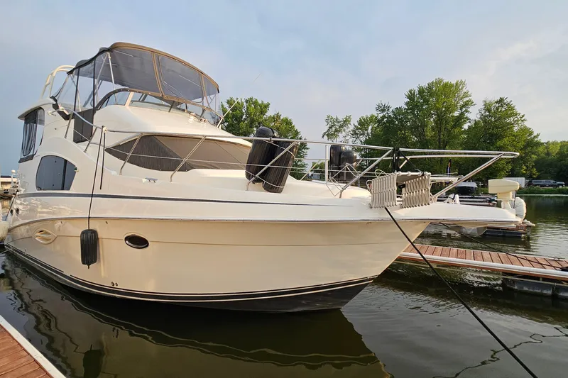 Slide: The Image of 2003 Silverton 35 Motor Yacht docked on a calm lake with trees in the background. - 4