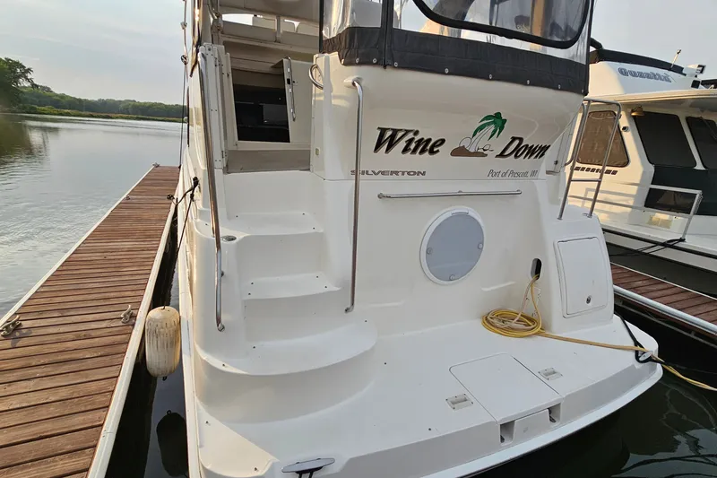 Slide: The Image of 2003 Silverton 35 Motor Yacht docked, featuring "Wine Down" name on the stern. - 6